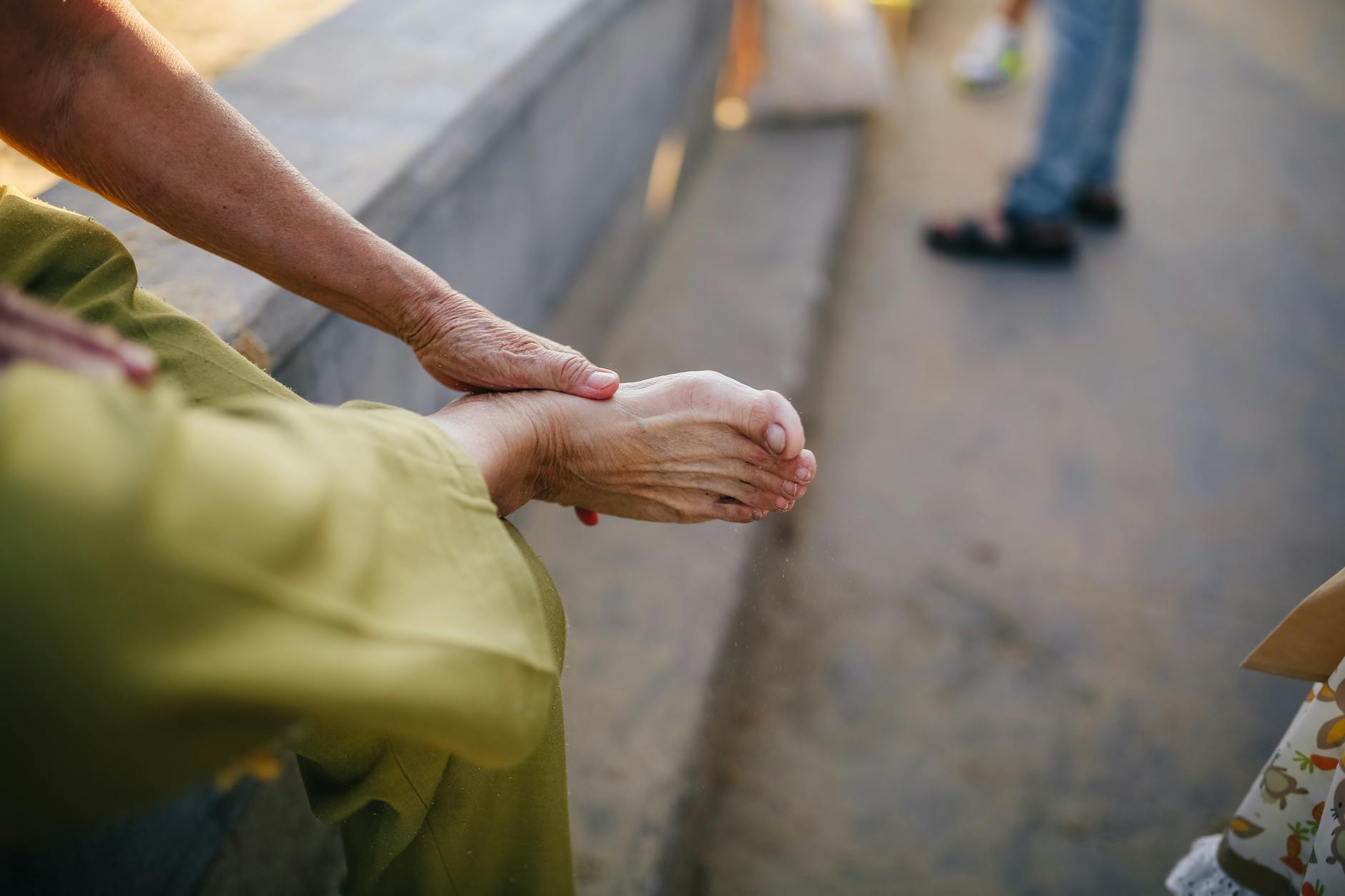 person in green pants sitting on gray concrete bench